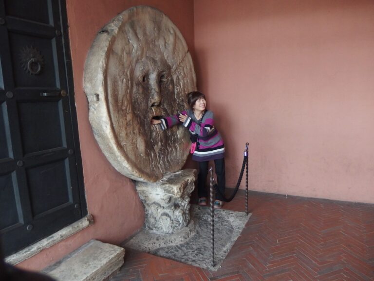 Tourist at the Bocca della Verità in Rome Putting her hand in the mouth of the monument