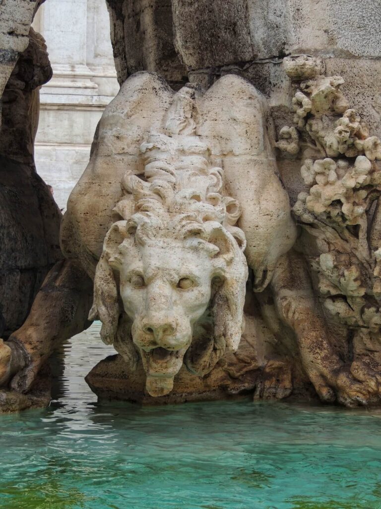 Bernini's sculpture of a lion lapping water from water's edge on the fountain of the four river in piazza navona in Rome