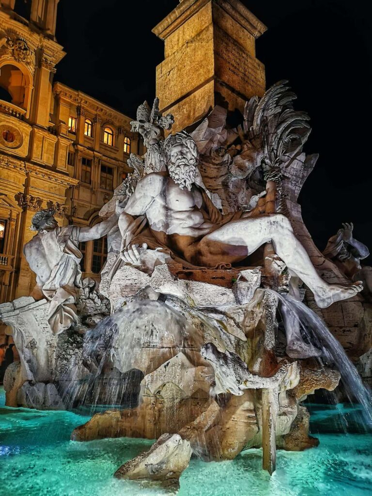 Fountain of the four rivers illuminated at night showing the statue of the personification of the river ganges