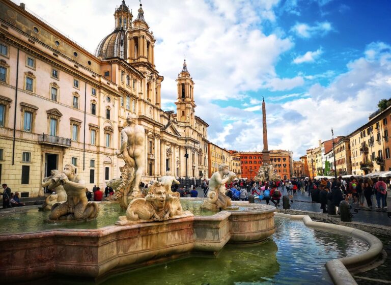 view of piazza navona from the southern end showing the fountain of the moor in the foreground with the fountain of the four rivers in the background and the church of st. agnes in agone