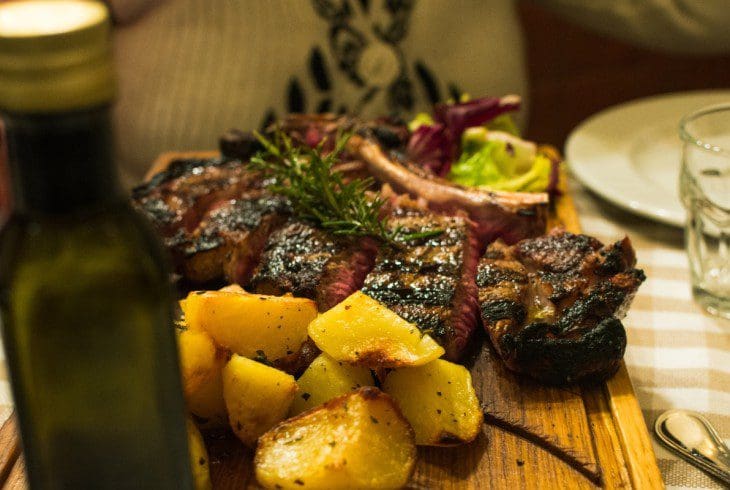 Bistecca alla Fiorentina with roast potatoes in a trattoria in Florence