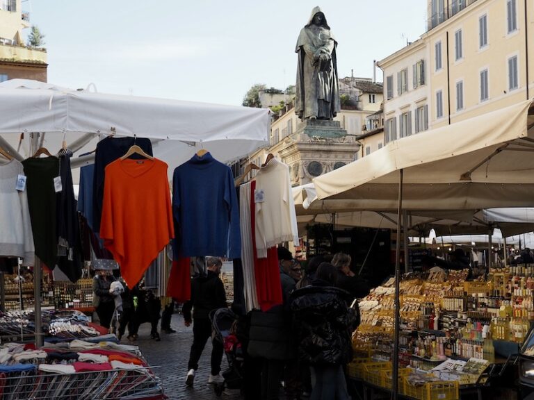 the bustling campo de'fiori market in rome beneath giordano bruno