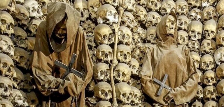 Capuchin Crypt in Rome showing the skeletons of two robed friars in niches made from human skulls