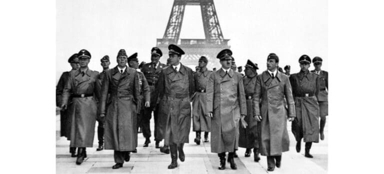 Black and White photo of Hitler walking with his aides in front of the Eiffel Tower in Pariss