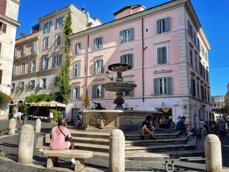View of Piazza della Madonna dei Monti in Rome with a fountain in the foreground and and buildings in the background