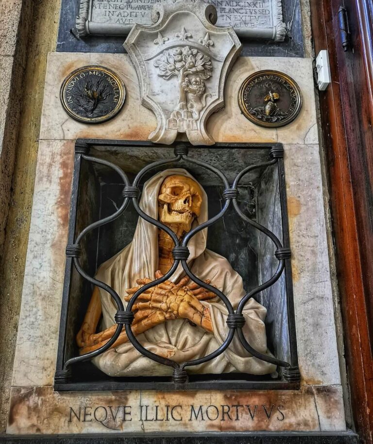 Funeral Monument to Gisleni in Sant Maria del Popolo Rome showing a veiled skelton in yellow marble with its arms crossed over its chest