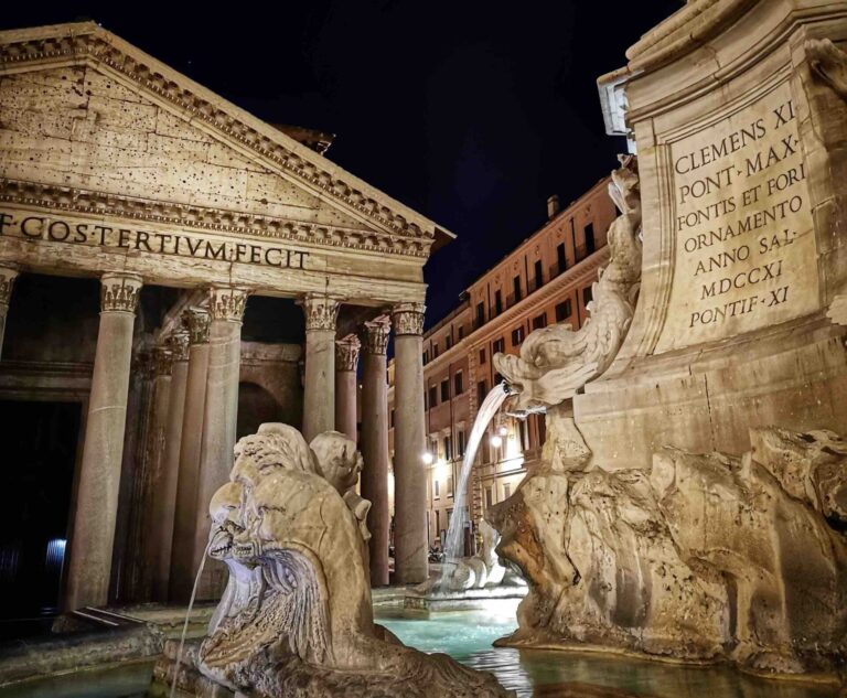 View of the fontana del Pantheon at night with the facade of the pantheon illuminated in the background