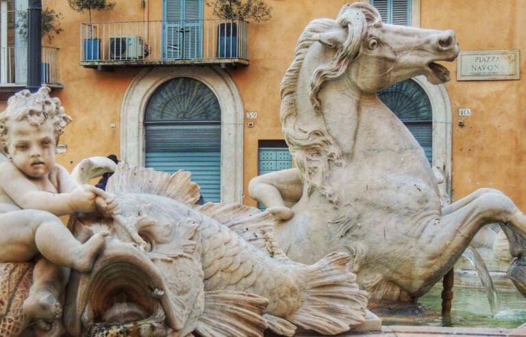 Close up detail of the fountain of the four rivers in piazza navona rome showing a a horse, fish and water nymphs