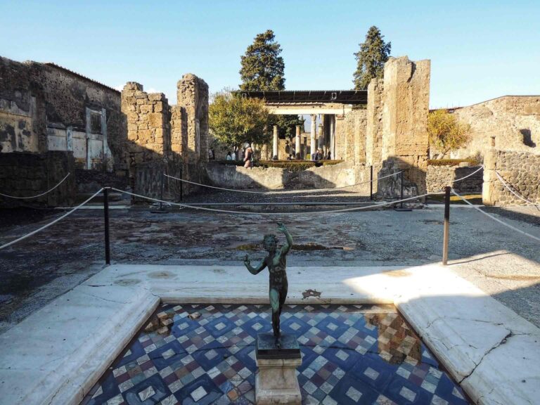 Atrium of the House of the Faun in Pompeii showing its namsake bronze statue of a faun in the centre of the impluvium pool with the rest of the villa sprawling out behind