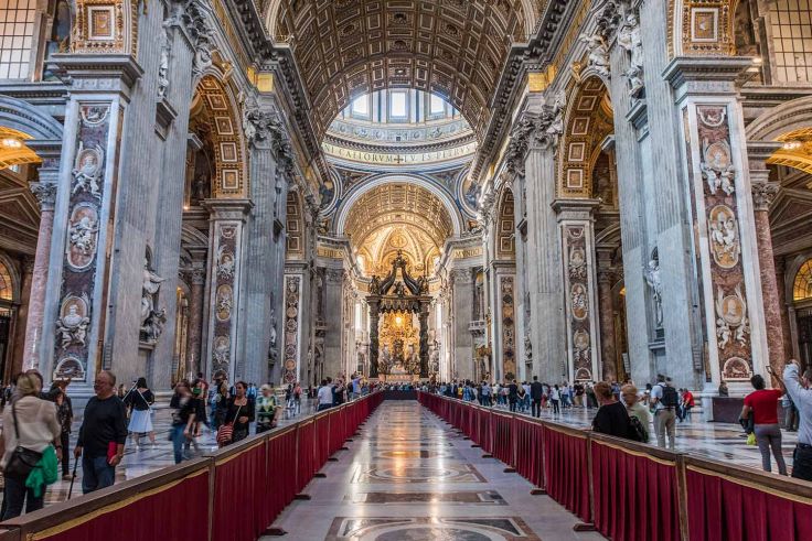 View of the central nave of st. peter's basilica with a view towards the papal altar and the baldacchino
