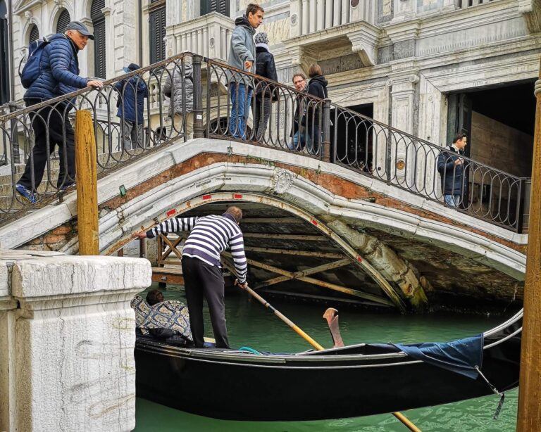 gondola going under a bridge in venice