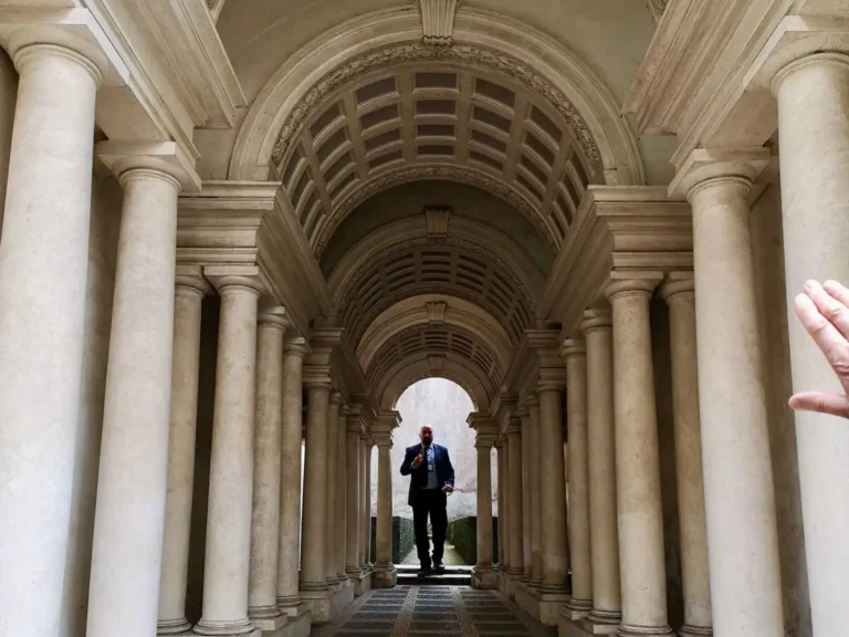 a man walks down borromini's corridor in rome