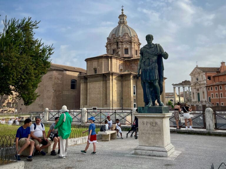 a statue of Julius Caesar in front of the the Roman Forum as perpetual dictator