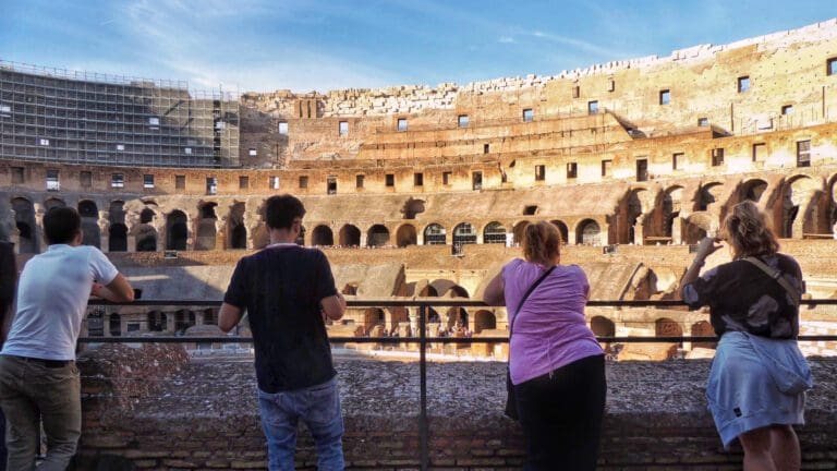 a colosseum group looks out over the arena floor from the second level of the amphitheater