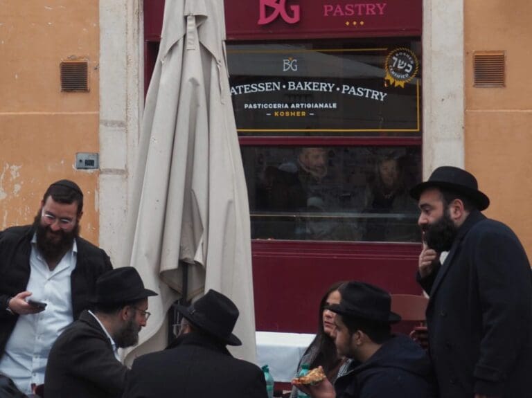 a crowd of people gather and eat beneath the window of BahGhetto in The Jewish Ghetto