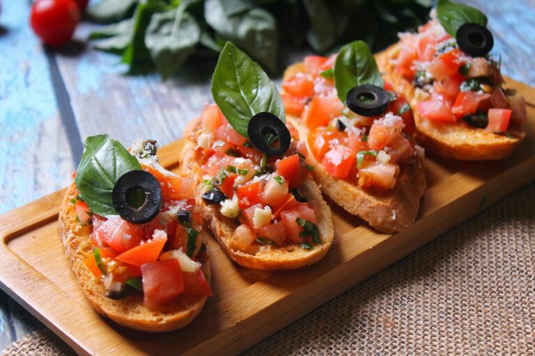 Canapes with tomato, basil and black olives served on a tray