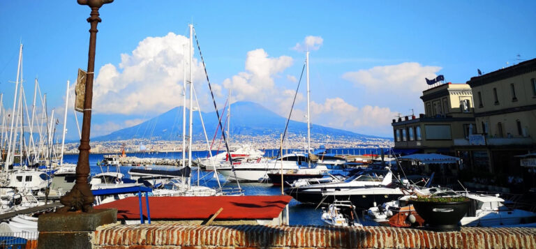 a view of naples harbor with mount vesuvius in the background