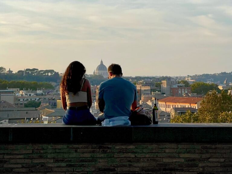 a couple looks out over rome from the garden of oranges on the aventine hill