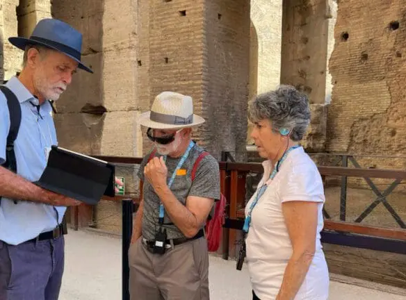 a colosseum guide shows clients reconstructions on an ipad